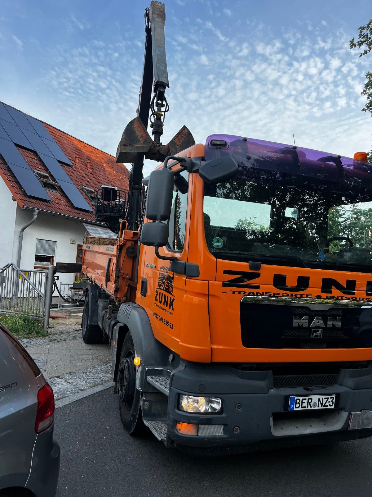 Nahaufnahme eines Zunk-Transporte-und-Entsorgung-Fahrzeugs mit Ladekran