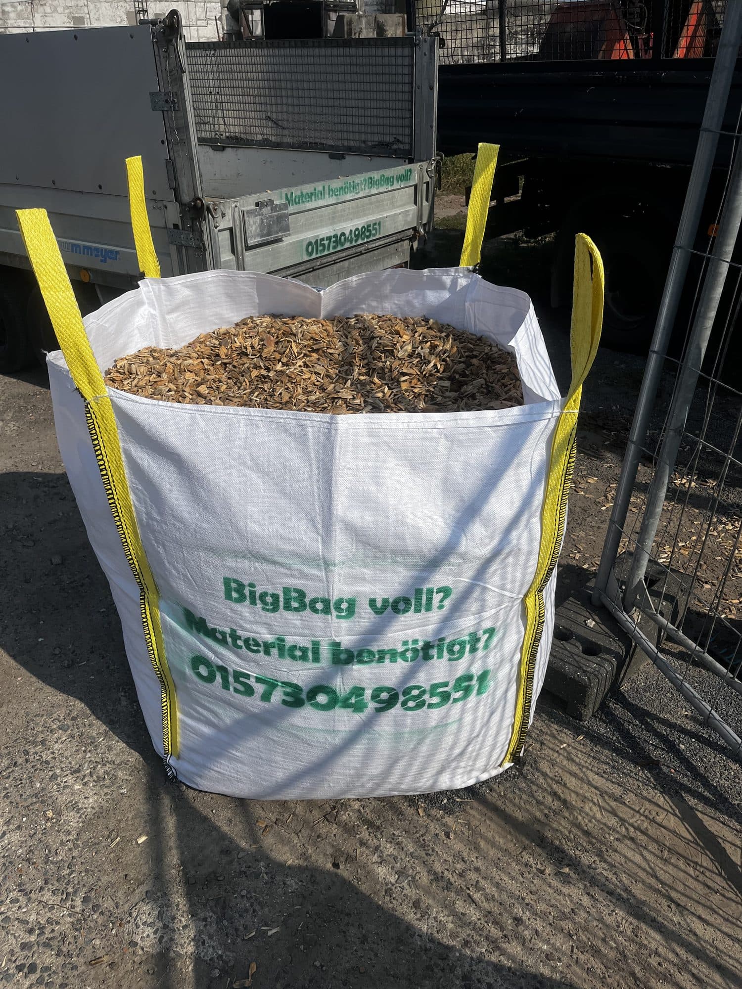 Original Zunk Big Bag Grüner Big Bag mit Zunk-Transporte-und-Entsorgung-Aufdruck wird per Ladekran-Greifer angehoben